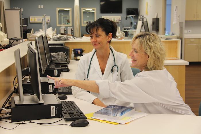 A team of healthcare professionals working at a computer.